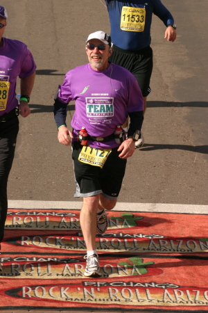 Tom Gilbert crossing the finish line of a marathon